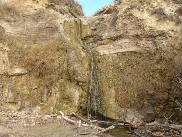 A waterfall whose water flows across the beach sands into the ocean — Crystal Cove State Park