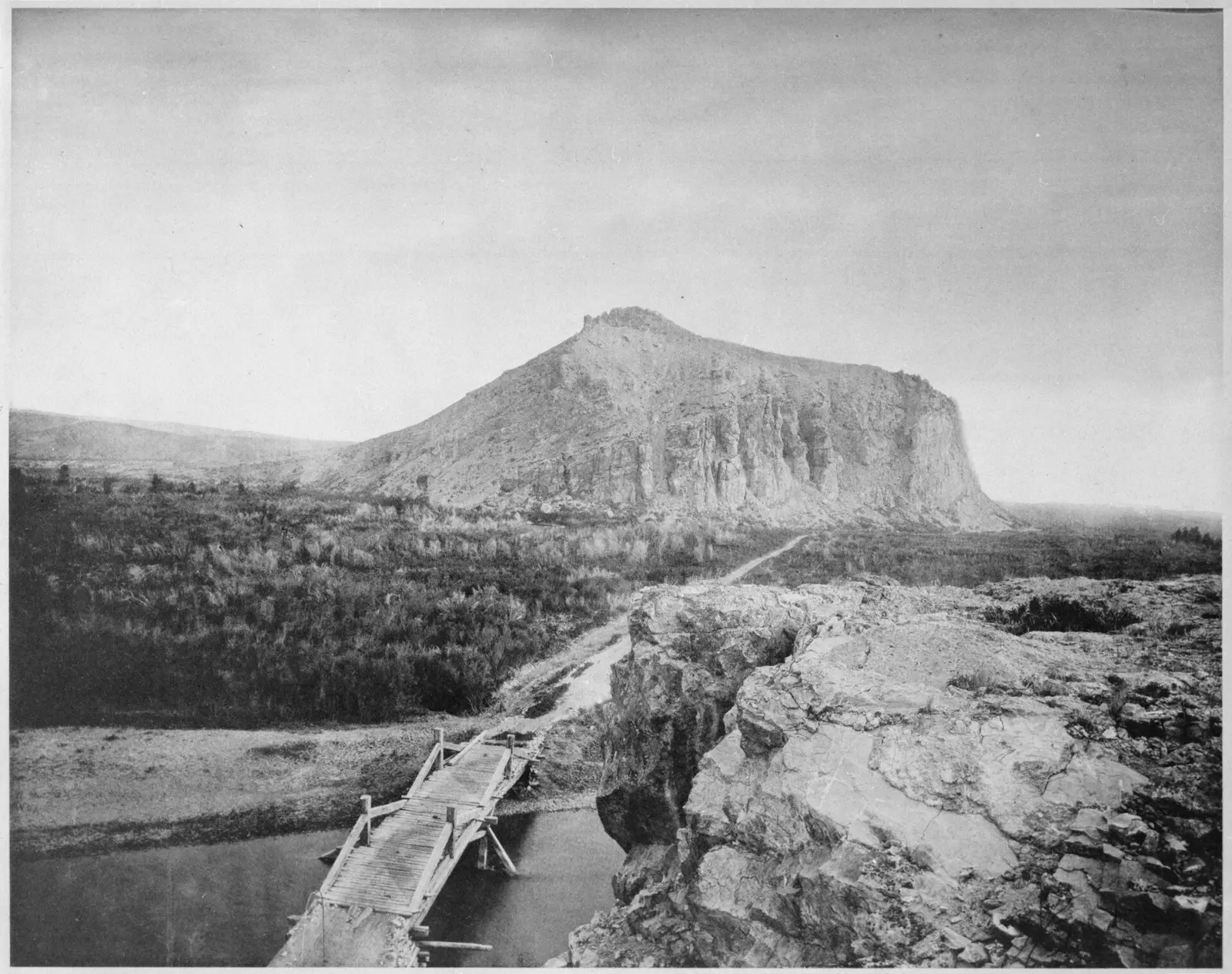 A wood plank bridge (forground) where the Overland Stage Line (abandoned in 1869) had crossed the Beaverhead River near Beaverhead Rock