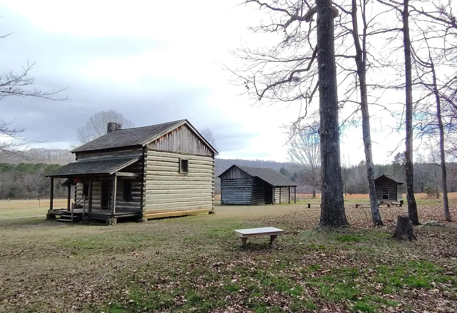 Replica of a Cherokee farmstead with a house, barn, and corncrib at Red Clay State Park