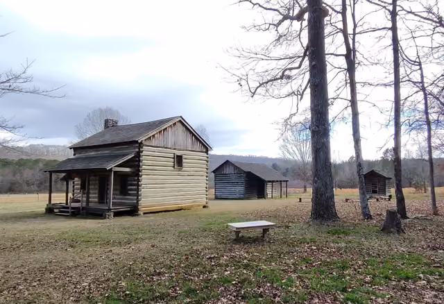 Replica of a Cherokee farmstead with a house, barn, and corncrib at Red Clay State Park